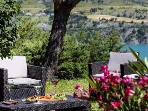 a table with a plate of food and a glass of wine at Logis Hotel Eden Lac in Savines