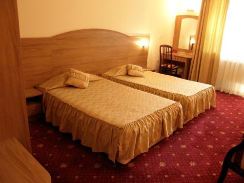 una camera d'albergo con due letti e un tavolo di Hotel Center ad Apriltsi