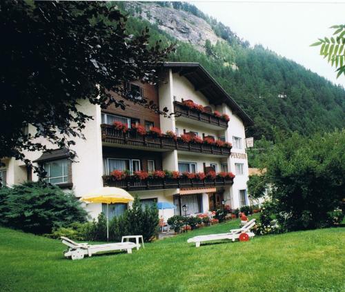 ein großes Gebäude mit Blumen auf den Balkonen in der Unterkunft Pension Grein in Pfunds