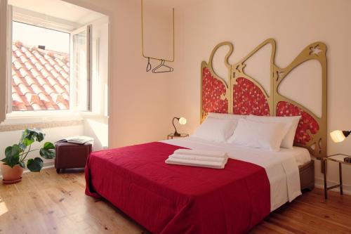 a bedroom with a bed with a red blanket and a window at Lisbon Calling Rooms & Studio in Lisbon