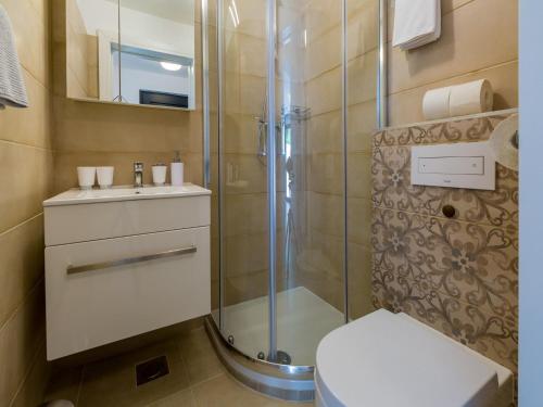 a bathroom with a shower and a toilet and a sink at Apartments Goldy in Crikvenica