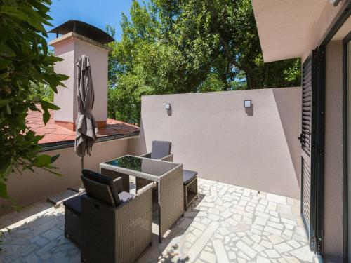 a patio with two chairs and an umbrella at Apartments Goldy in Crikvenica