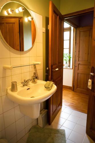 une salle de bain avec un lavabo et un miroir dans l'établissement Ferme du Mouchel, à Formigny