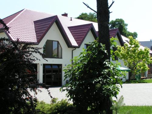 une maison blanche avec un toit rouge dans l'établissement Hotel i Restauracja Jan, à Bełchatów