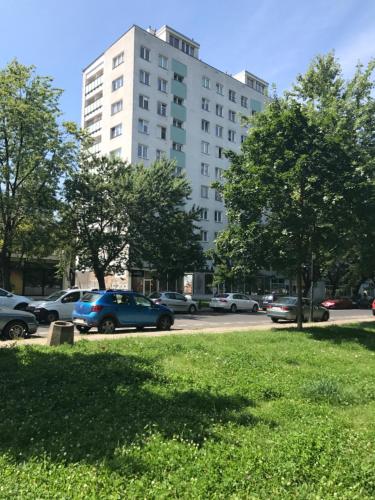 a large white building with cars parked in a parking lot at Apartament Karmelicka 19 Muzeum Polin in Warsaw