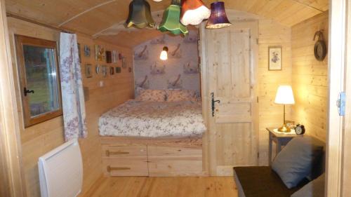 a bedroom with a bed in a tiny house at Roulottes Django et Bella in Gueberschwihr