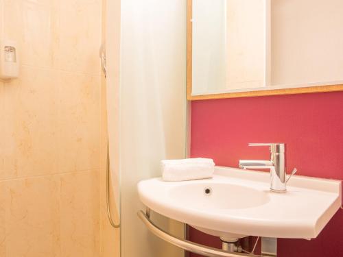 a bathroom with a sink and a mirror at B&B HOTEL Hyeres in Hy&egrave;res