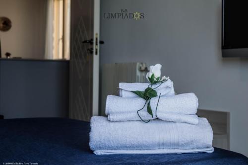 einen Stapel Handtücher mit einer Blume darüber in der Unterkunft Limpiados Bed & Breakfast in Licata