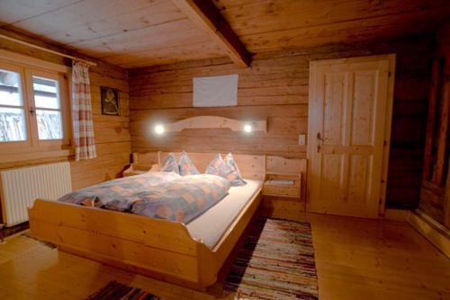 a bedroom with a bed in a wooden cabin at Ferienhaus Grubhof in Saalbach Hinterglemm