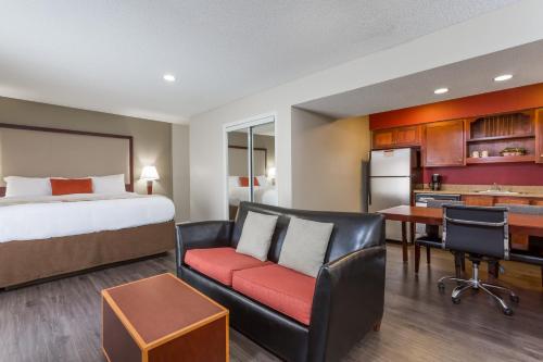 a hotel room with a bed and a desk and a kitchen at Hawthorn Suites By Wyndham North Charleston in Charleston