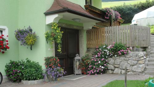 a house with flowers in front of a door at Panoramahotel Stocker in Pruggern