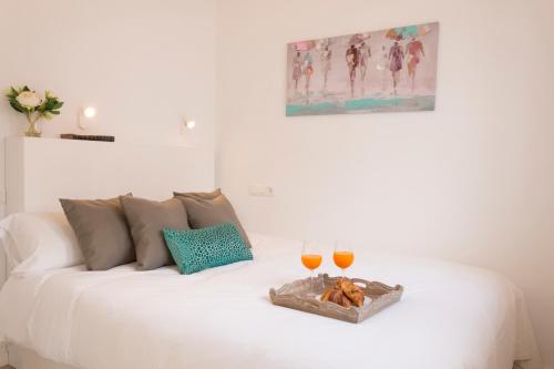 a white couch with two glasses of wine at Living4Malaga Atico Cervantes in Málaga
