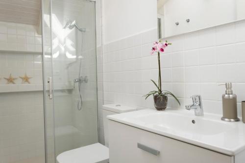 a white bathroom with a sink and a shower at Living4Malaga Atico Cervantes in Málaga