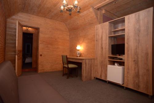 a room with a desk with a television and a table at Chateau Chikovani in Gordi
