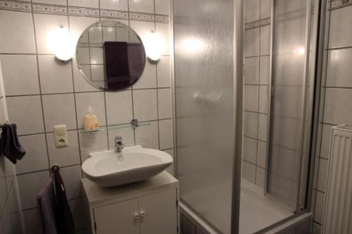 a bathroom with a sink and a shower and a mirror at Ferienwohnung Meuser in Traben-Trarbach