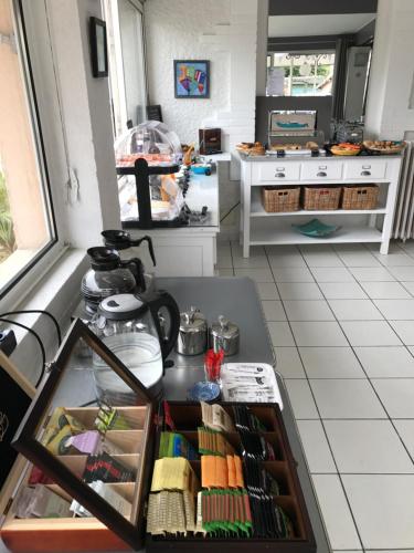 - une cuisine avec un comptoir et une table dans une pièce dans l'établissement Hôtel Villa Teranga, à Andernos-les-Bains