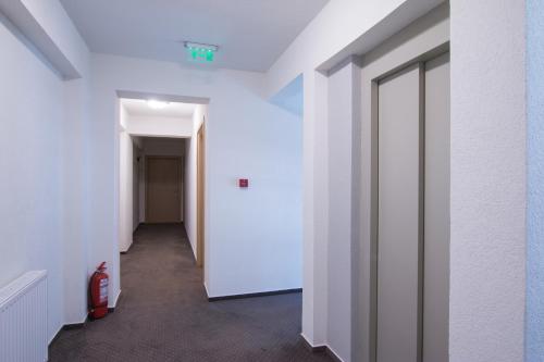 a hallway with white walls and a white door at Victoriei City Studios in Bucharest