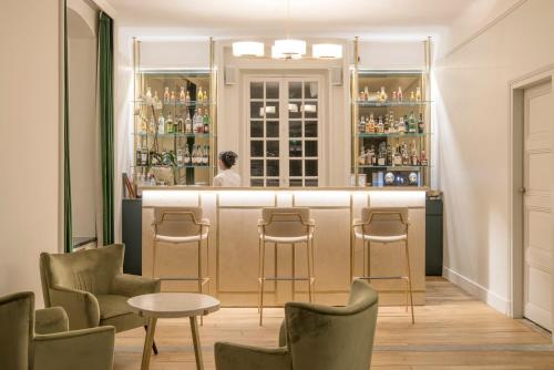 un bar avec des chaises et une personne en arrière-plan dans l'établissement Hôtel Restaurant De La Poste & Du Lion D'or, à Vézelay