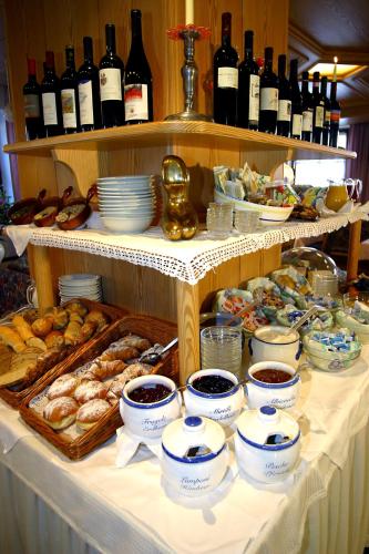 a buffet of food and bottles of wine on a table at Piccolo Hotel Gurschler in Maso Corto