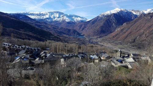 a village in a valley with snow capped mountains at Apartamentos Ball Benas Edificio Prados de Velarta in Cerler