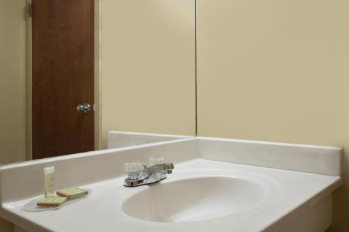 a bathroom sink with a mirror and a faucet at Super 8 by Wyndham Mount Vernon, IL in Mount Vernon