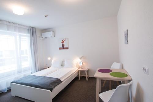 a bedroom with a bed and a desk and a window at Victoriei City Studios in Bucharest