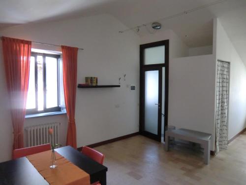 オルヴィエートにあるAppartamento Arancioのリビングルーム(テーブル付)、窓、ドアが備わります。