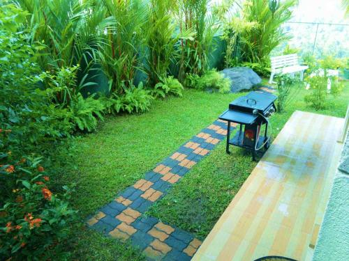 a brick pathway with a bench in a garden at Kandy Royal Resort in Kandy