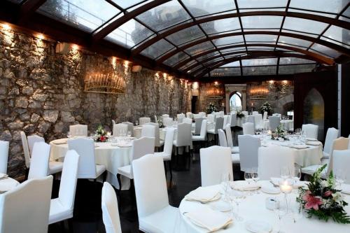 a dining room with white tables and white chairs at Hotel Castillo de Arteaga in Gautegiz Arteaga