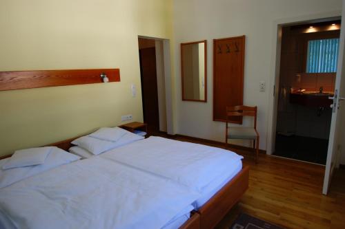 a bedroom with a white bed and a sink at Bertricher Hof Hotel Garni in Bad Bertrich