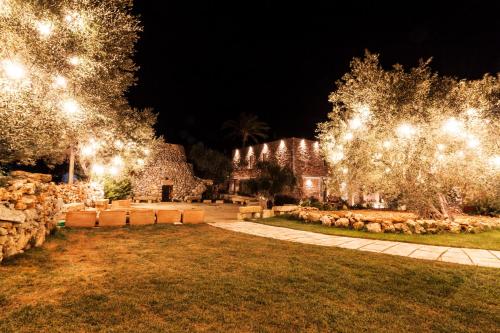 a garden at night with lights on trees at Montiro' Hotel in Leuca
