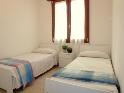 2 camas en una habitación con 2 ventanas en Villa Giuri, en Lido di Pomposa