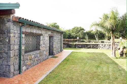 a stone building with a window and a yard at Il Rustico in Pozzillo