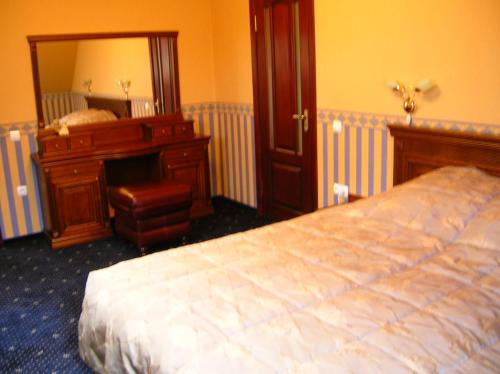 a bedroom with a bed and a mirror and a desk at Zolotoie Runo in Skhidnitsa