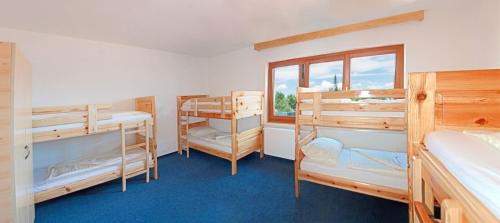 a bedroom with three bunk beds and a window at Gasthaus Pension Goldeck in Spittal an der Drau