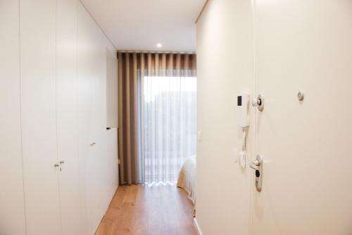 a white room with a door and a bedroom at Terro Collection - Alcaide in Braga