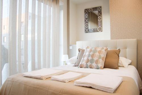 a bedroom with a large bed with two towels on it at Braga Center Apartments - Rua do Alcaide in Braga