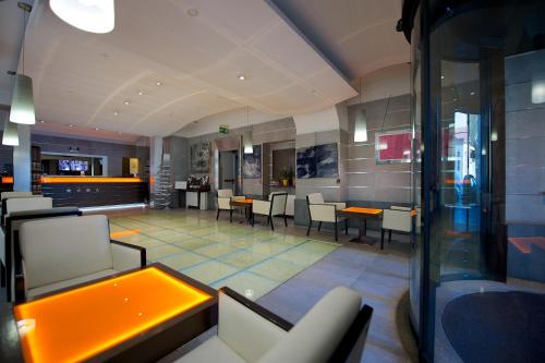 restauracja z krzesłami i stołami w budynku w obiekcie Best Western Crystal Palace Hotel w Turynie