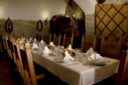 a long table with plates and napkins on it at Hotel Zámeček Pod Hradem Starý Jičín 111 in Starý Jičín
