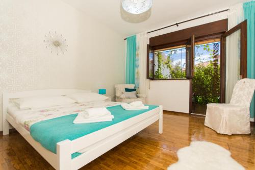 a bedroom with a white bed and a window at Apartment Lorenzo in Trogir