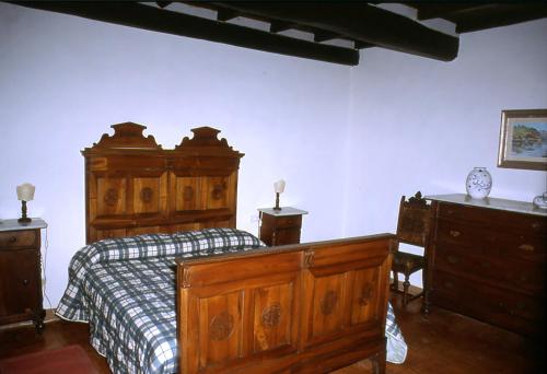 una camera con letto in legno e cassettiere in legno di Frascole a Dicomano