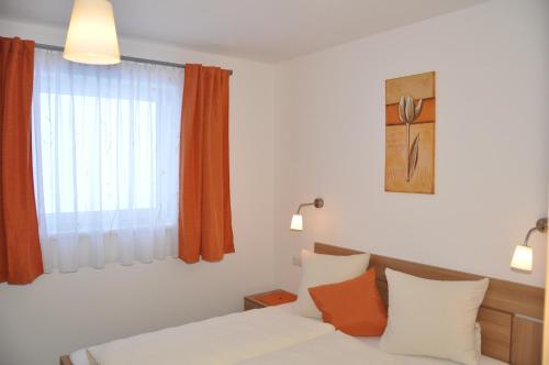 a bedroom with a bed with orange and white pillows at Appartements Montana in Vent