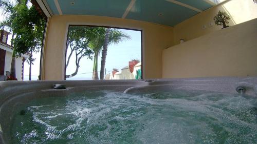 a hot tub in a room with a large window at Villa Necho in La Orotava