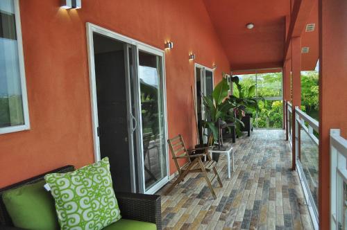 an orange house with a balcony with a couch and chairs at Casa Donna Rosa B&B in Nuevo Arenal