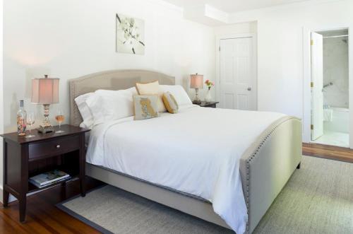 a bedroom with a large white bed with a night stand at West Neck Guesthouse in Shelter Island Heights