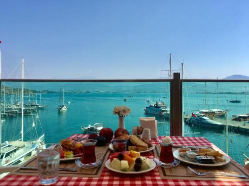 una mesa con comida y vistas al puerto deportivo en Alesta Yacht Hotel, en Fethiye