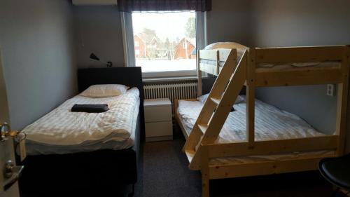 Bygdeå的住宿－Motell Trafikanten，一间卧室设有两张双层床和一扇窗户。