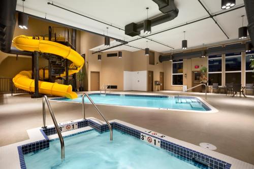 a large swimming pool with a slide in a building at Microtel Inn & Suites by Wyndham Lloydminster in Lloydminster