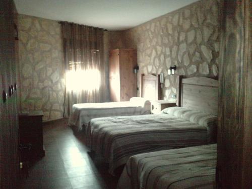 a hotel room with three beds in a room at Posada de los Cónsules in Consuegra