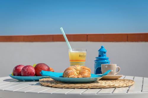 a table with a plate of fruit and a glass of juice at B&B Vistamare Suite in Agropoli
